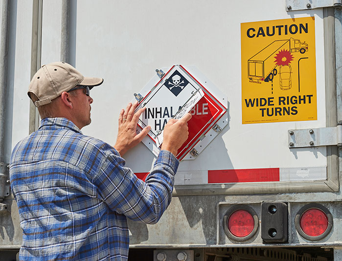 Driver changing placard in the back of trailer