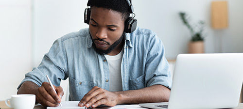 African american learner in headphones studying through online training