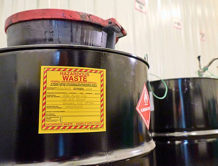 Black metal barrels with hazardous waste labels